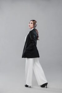 Woman wearing a black blazer and white wide-leg trousers from the Spring Work Wear Edit.