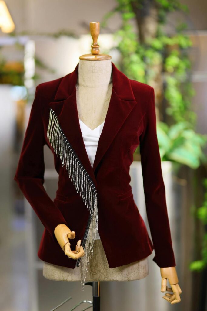 A burgundy velvet blazer shown on a clothing form from the Spring Work Wear Edit.