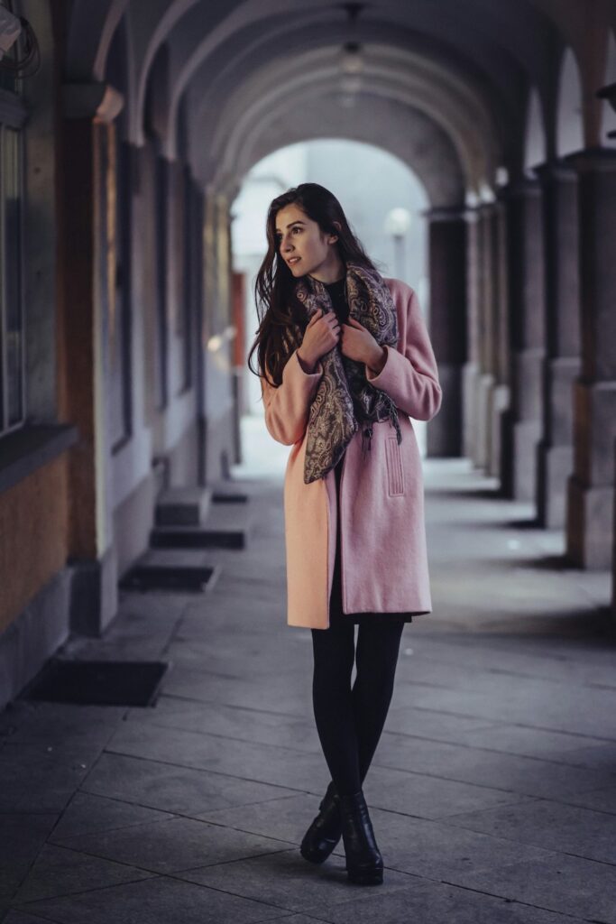 Luxury casual outfits featuring a pastel pink winter coat and textured scarf styled for a feminine winter look.