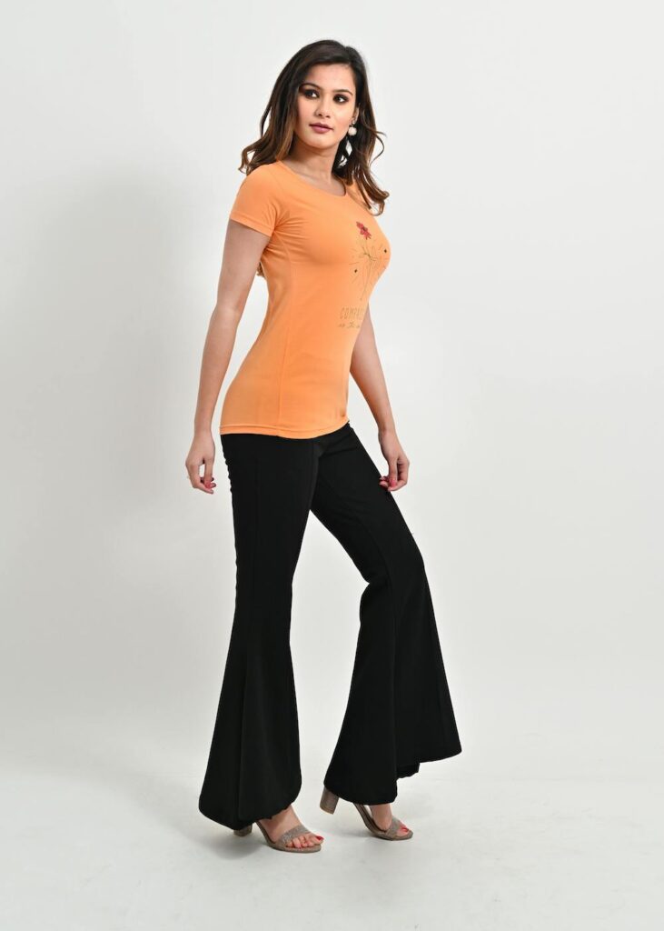 Modern tailored style peach top and black flared trousers.